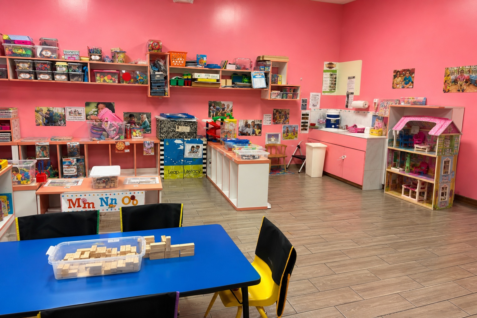 Bright pink Pre-K classroom with learning centers, activity tables, blocks, and organized educational materials